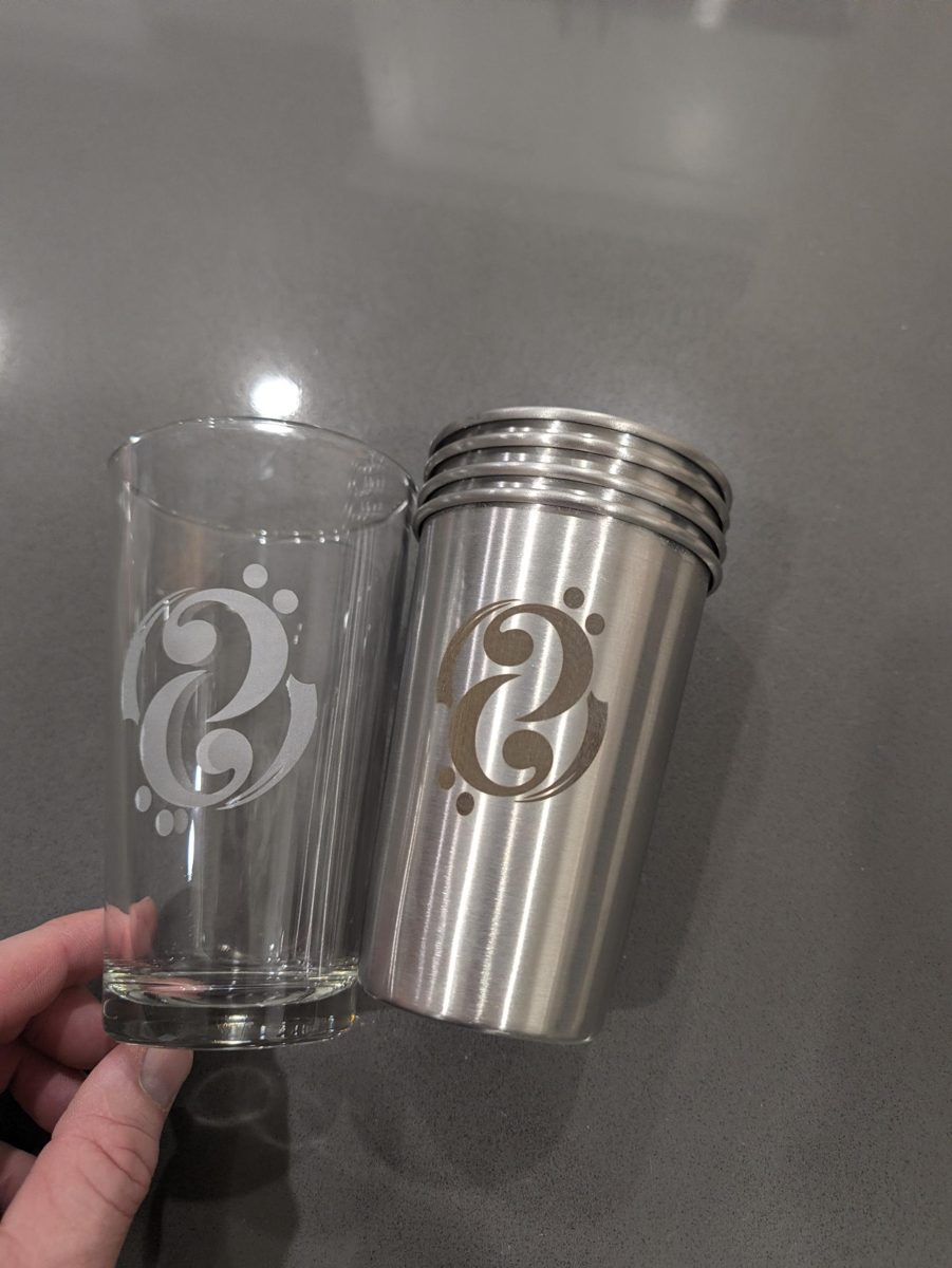 Logo laser engraved on a glass pint and stacked stainless steel cups