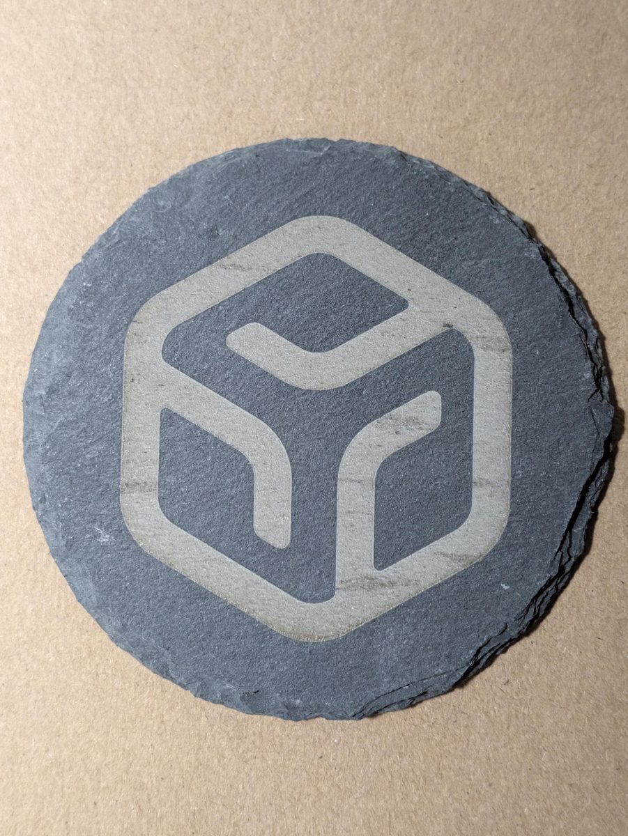 Round slate coaster with a laser engraved company logo